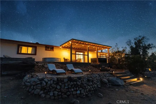 a backyard of a house with table and chairs fire pit