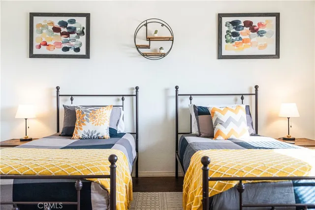 a bedroom with two beds and a painting on the wall