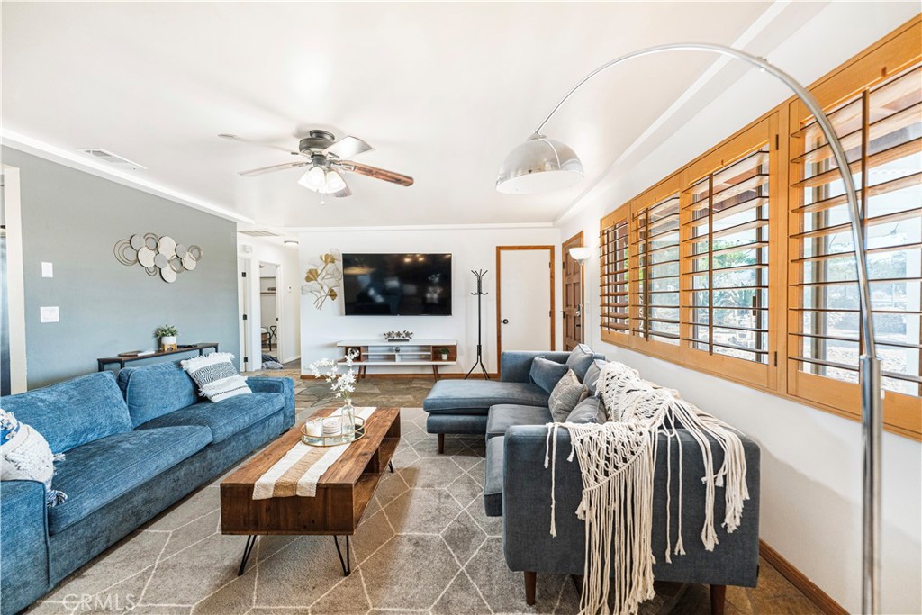 7071 Rubidoux Avenue Yucca Valley, CA 92284 - Photo 37 of 50 a living room with furniture ceiling fan and a flat screen tv