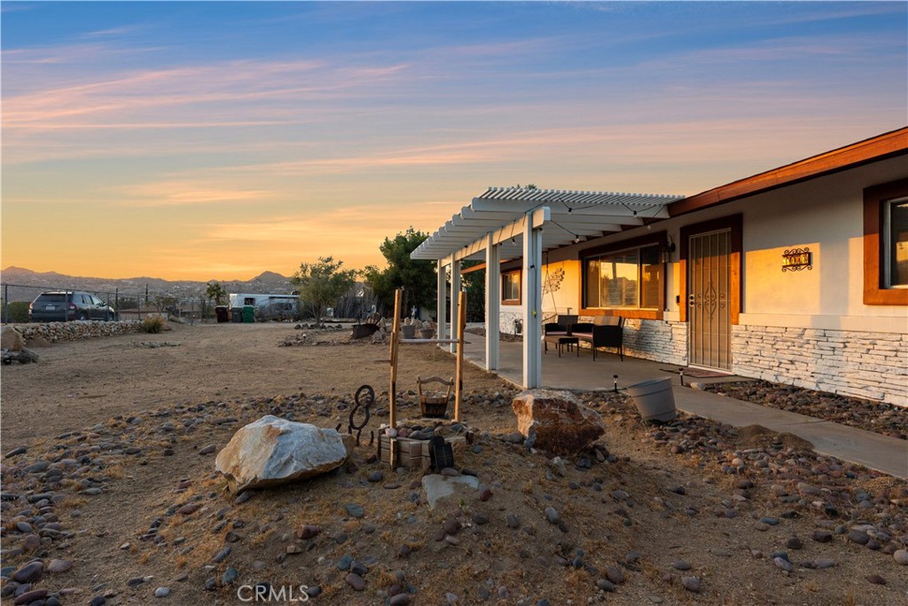 7071 Rubidoux Avenue Yucca Valley, CA 92284 - Photo 4 of 50 a view of a backyard with table and chairs under an umbrella