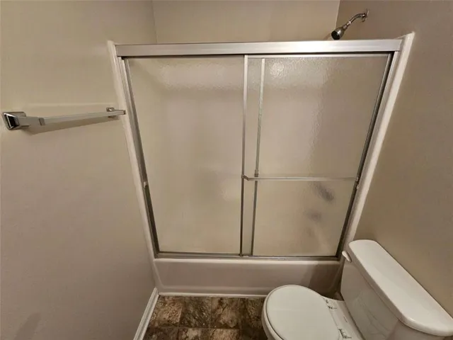 a bathroom with a toilet and a shower
