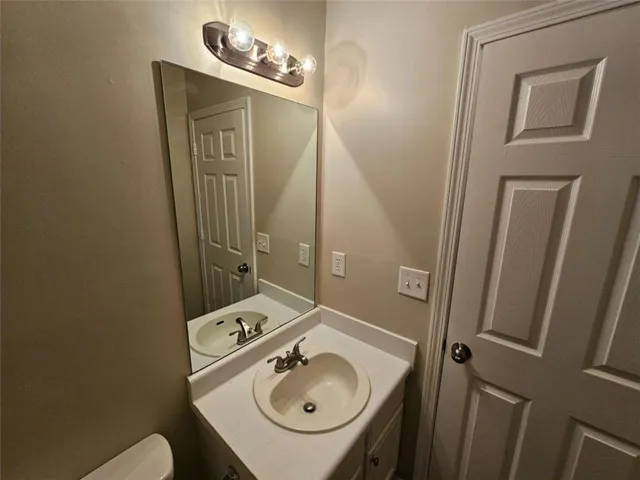 a bathroom with a sink a toilet and mirror