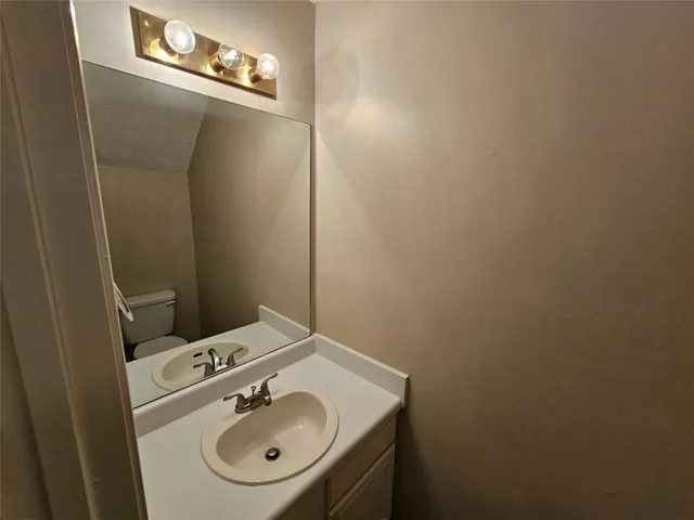 a bathroom with a sink a toilet and a mirror