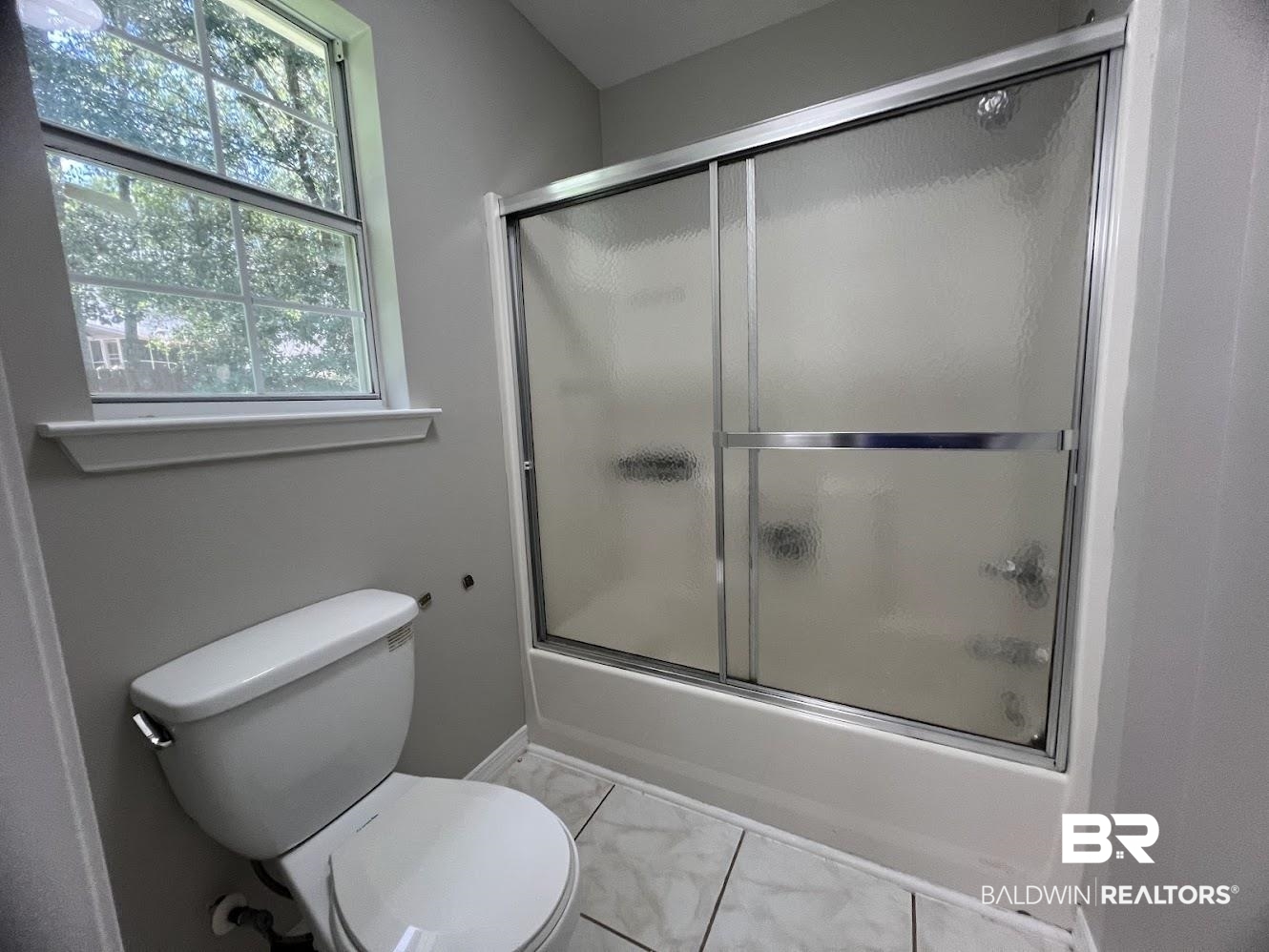 266 Ridgewood Drive Daphne, AL 36526 - Photo 15 of 34 Bathroom featuring a white toilet, tile flooring, and a white tub with sliding textured glass doors