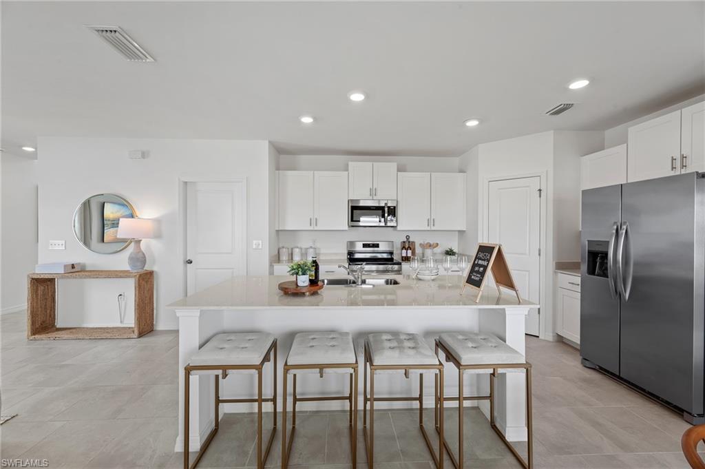 17251 Monte Isola Way North Fort Myers, FL 33917 - Photo 11 of 39 a kitchen with a table chairs microwave and refrigerator