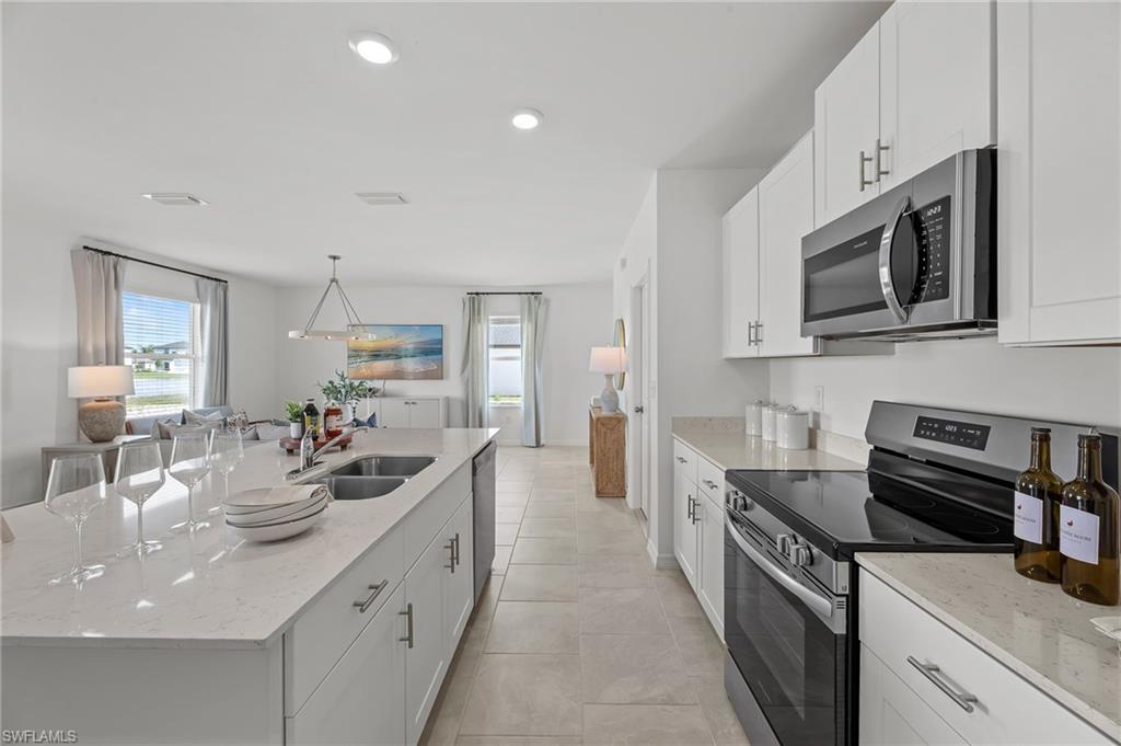 17251 Monte Isola Way North Fort Myers, FL 33917 - Photo 13 of 39 a kitchen with stainless steel appliances granite countertop a sink stove and microwave