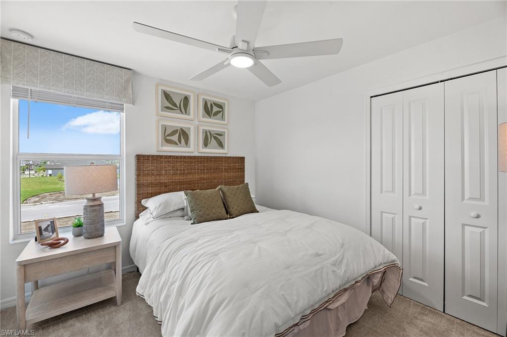 17251 Monte Isola Way North Fort Myers, FL 33917 - Photo 20 of 39 a bedroom with a large bed and a chandelier