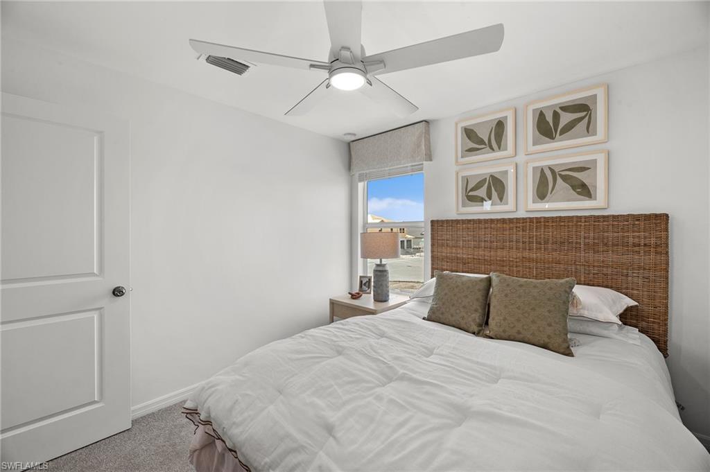 17251 Monte Isola Way North Fort Myers, FL 33917 - Photo 21 of 39 a bedroom with a large bed and a chandelier