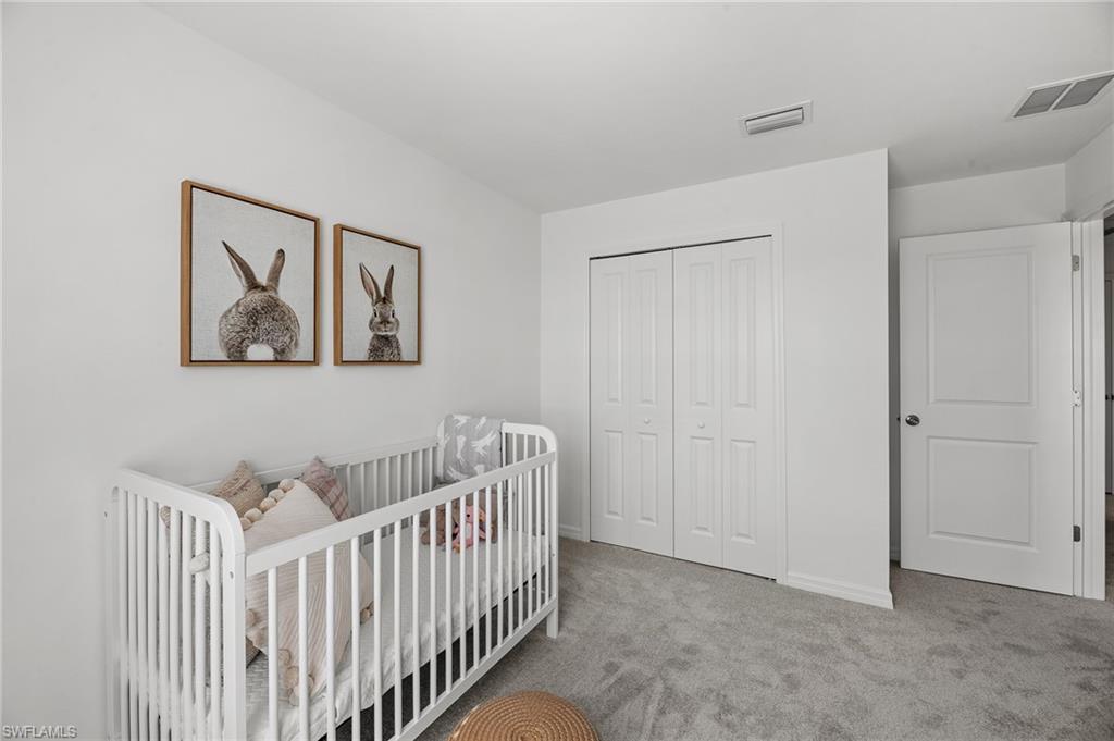 17251 Monte Isola Way North Fort Myers, FL 33917 - Photo 24 of 39 a view of a bedroom with baby crib and wooden floor