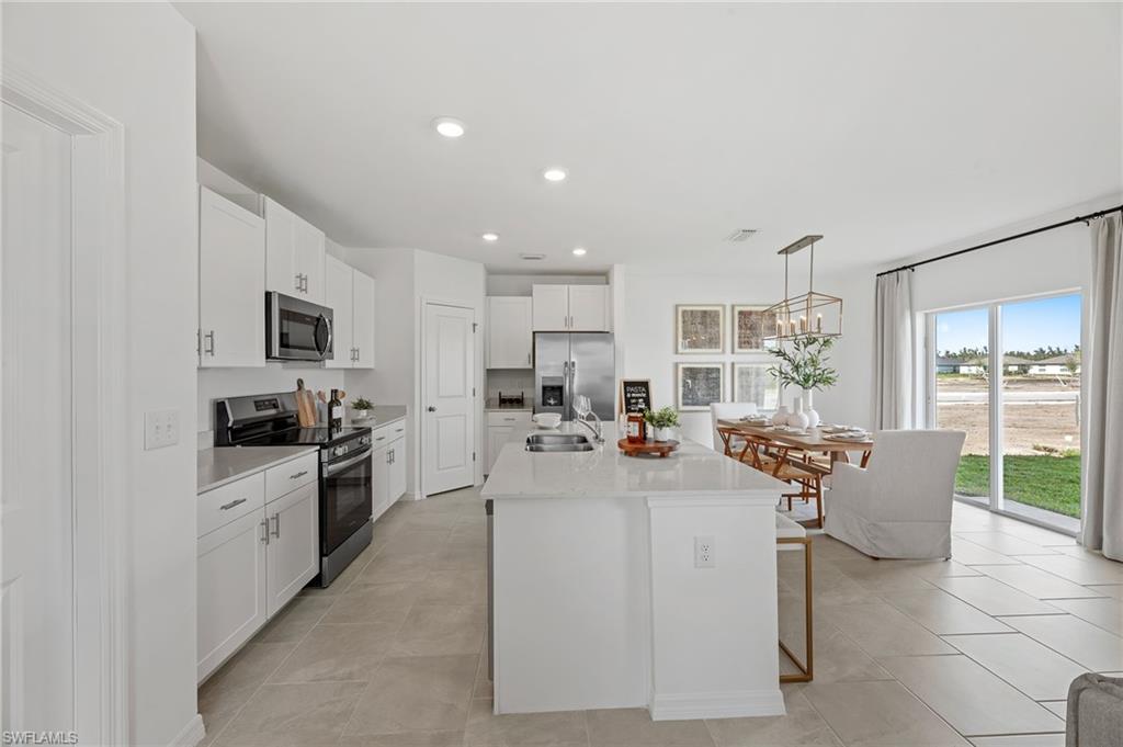 17251 Monte Isola Way North Fort Myers, FL 33917 - Photo 9 of 39 a kitchen with stainless steel appliances kitchen island granite countertop a sink and cabinets
