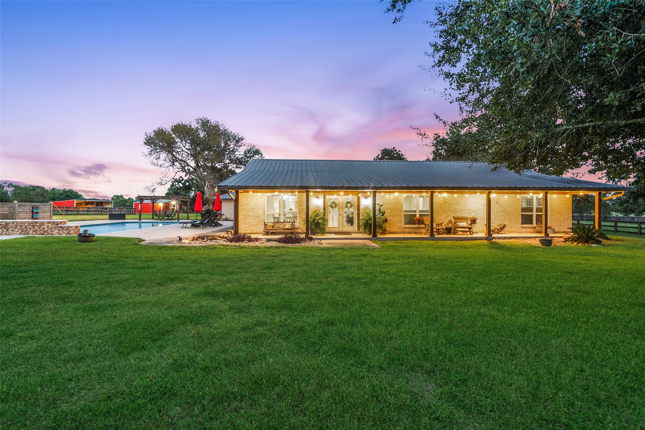 Striking front view with a durable metal roof, upgraded Hardiplank siding, and expansive lawn creating timeless curb appeal.