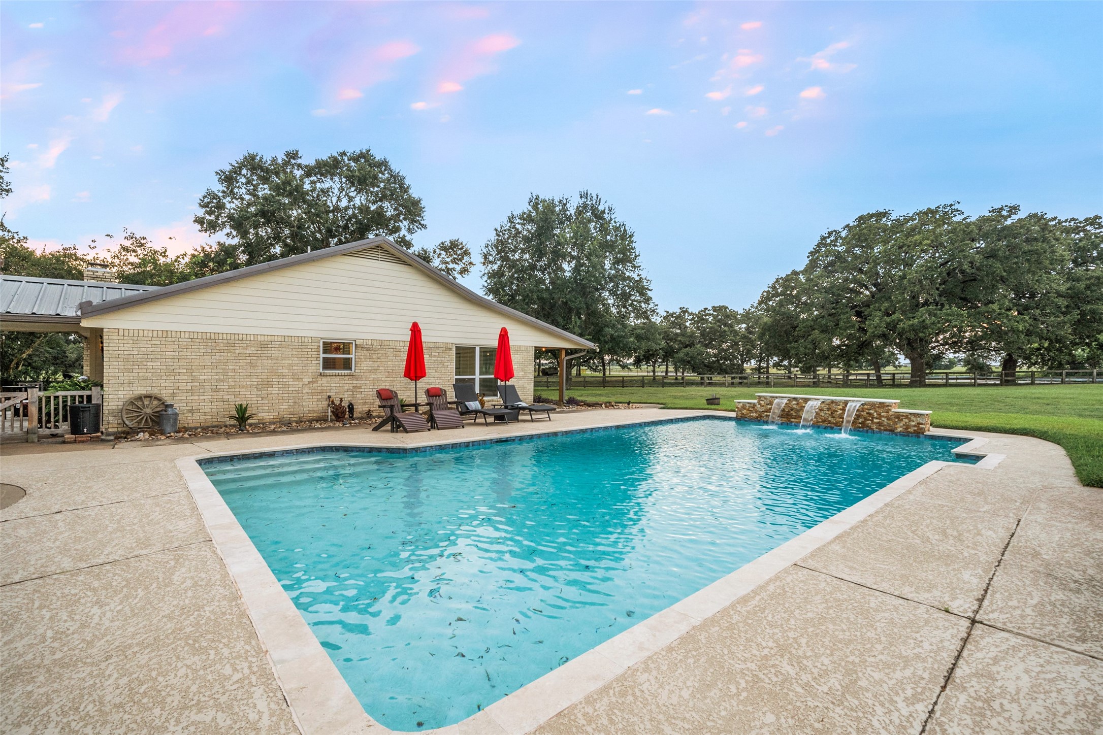21348 Farm To Market 359 Hempstead, TX 77445 - Photo 5 of 48 Bright daytime pool view highlights the cascading waterfall fountain, resurfaced finish, and cool deck.