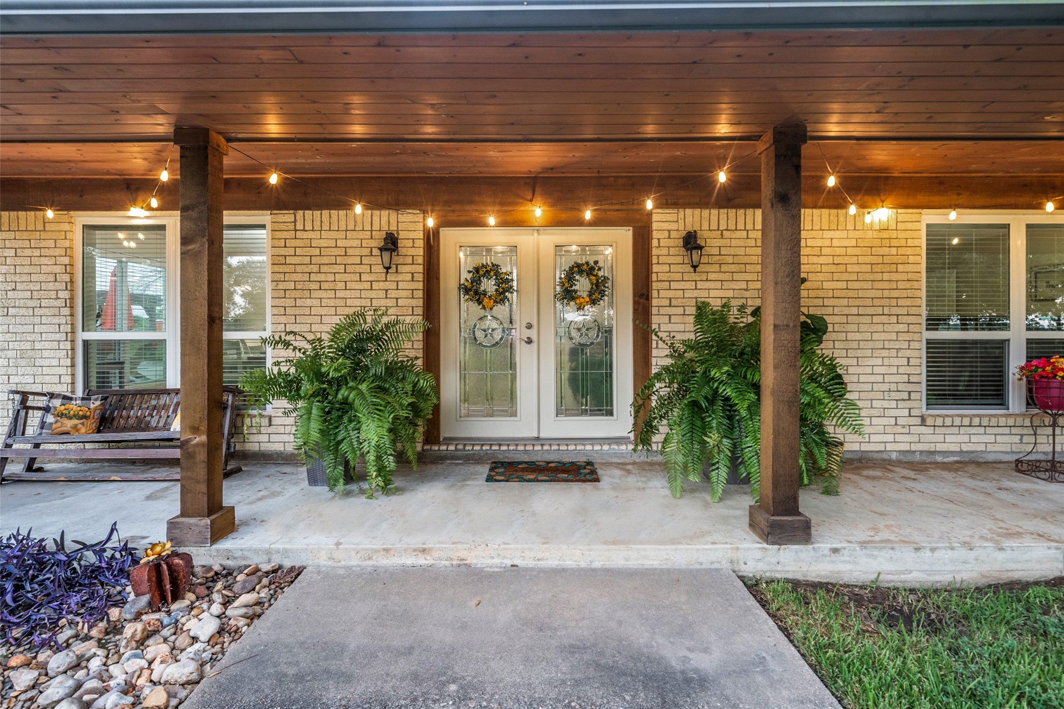 21348 Farm To Market 359 Hempstead, TX 77445 - Photo 9 of 48 Inviting covered porch with wood ceiling detail, cedar columns, and upgraded lead-glass French doors.