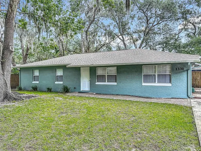 a house that has a tree in front of a house