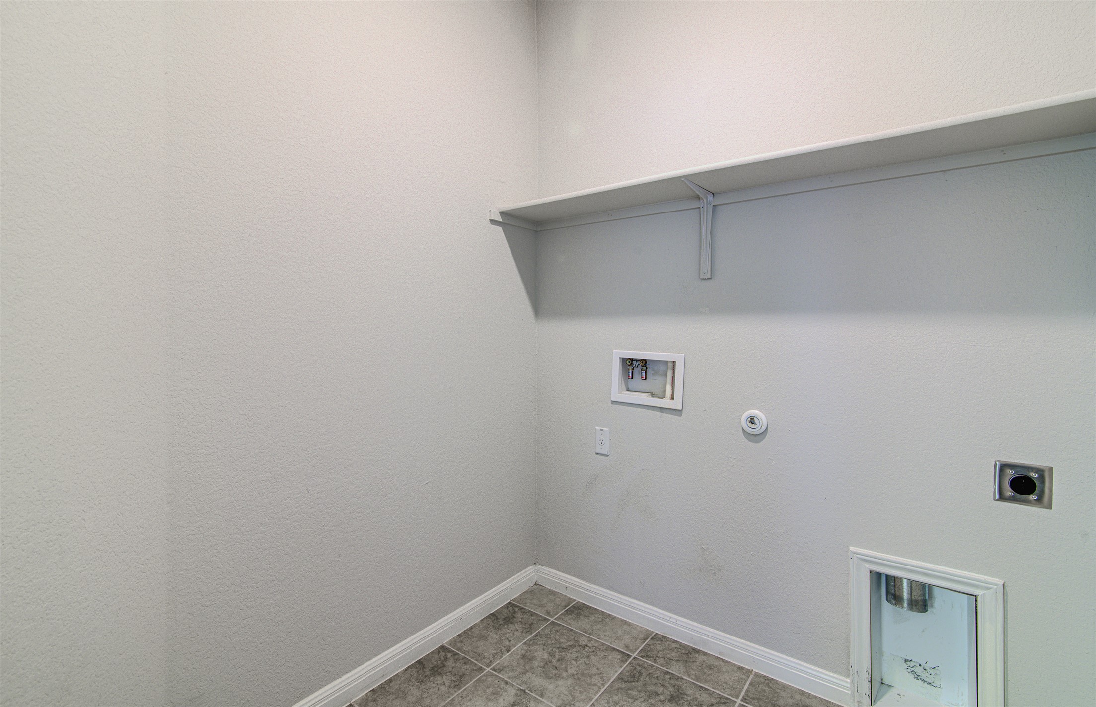 316 Pepper Mill Loop Burnet, TX 78611 - Photo 22 of 27 Functional utility room with tiled flooring and convenient wall-mounted shelving.
