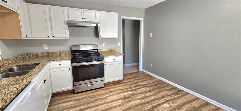 1120 Rappahannock Drive Alpharetta, GA 30009 - Photo 10 of 35 a kitchen with granite countertop white cabinets and white appliances