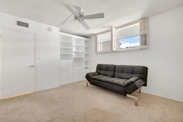 a living room with furniture and a ceiling fan