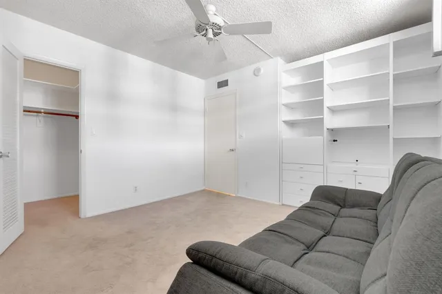 a living room with furniture and a ceiling fan