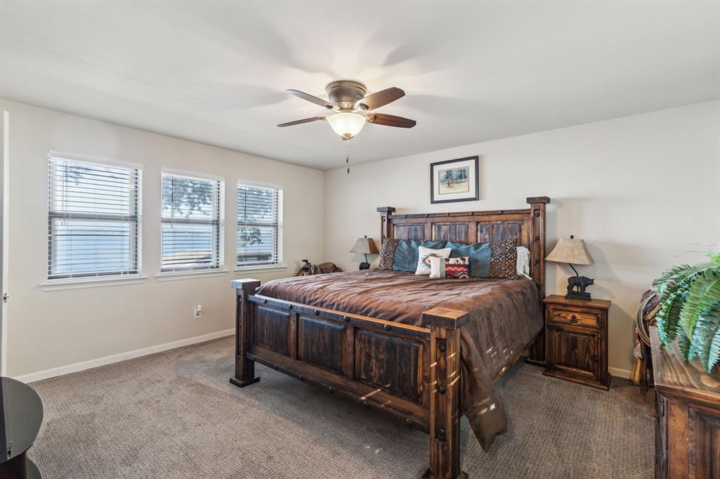 142 Peninsula Point Terrace Mabank, TX 75156 - Photo 12 of 29 a bedroom with a bed and a chandelier