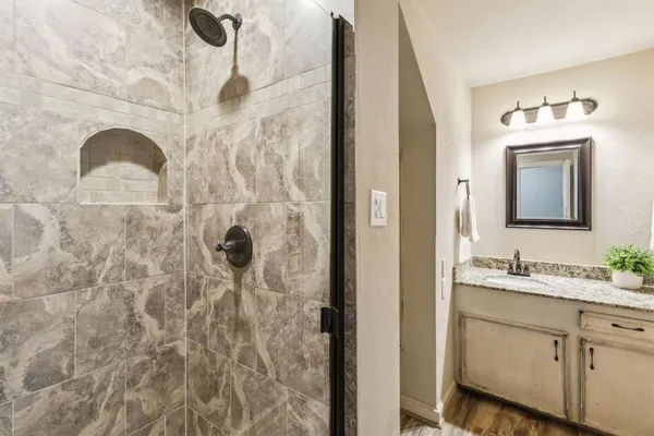 a bathroom with a double vanity sink mirror and shower