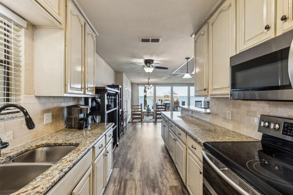 142 Peninsula Point Terrace Mabank, TX 75156 - Photo 20 of 29 a kitchen with stainless steel appliances granite countertop a stove and a sink