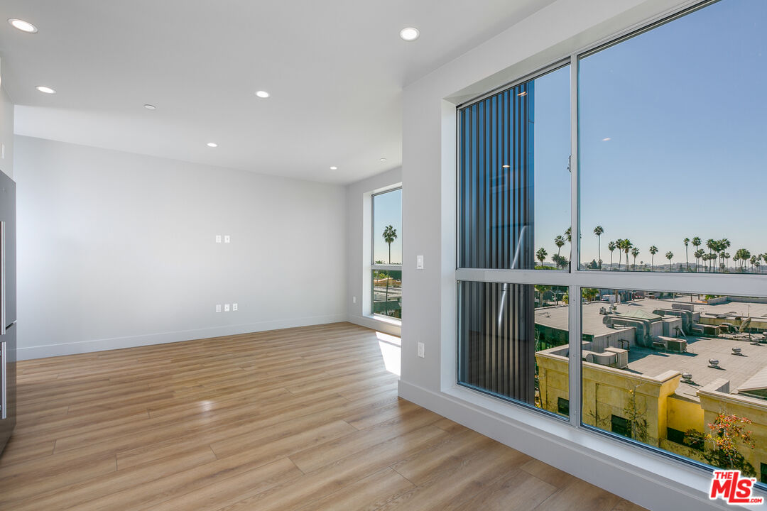 12431 Rochester Avenue, Unit 206 Los Angeles, CA 90025 - Photo 6 of 23 a view of a living room and kitchen with wooden floor