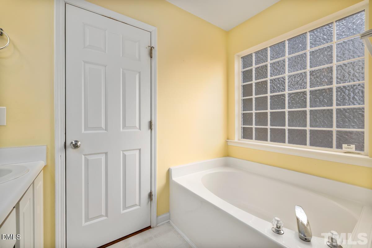 3617 Hamilton Mill Drive Raleigh, NC 27616 - Photo 13 of 20 a bathroom with a bathtub and a window