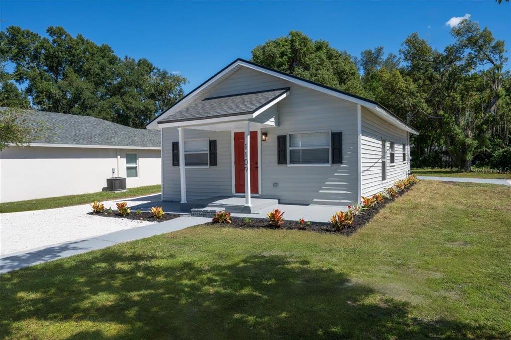 a view of a house with backyard and sitting area