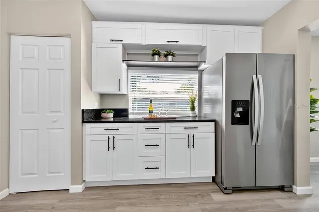 a kitchen with stainless steel appliances granite countertop a refrigerator and a stove