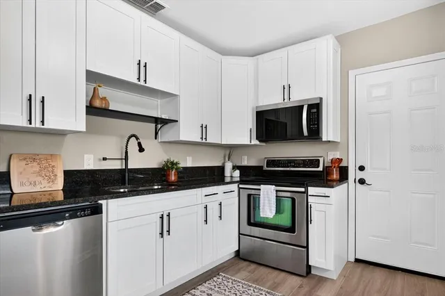 a kitchen with white cabinets and appliances