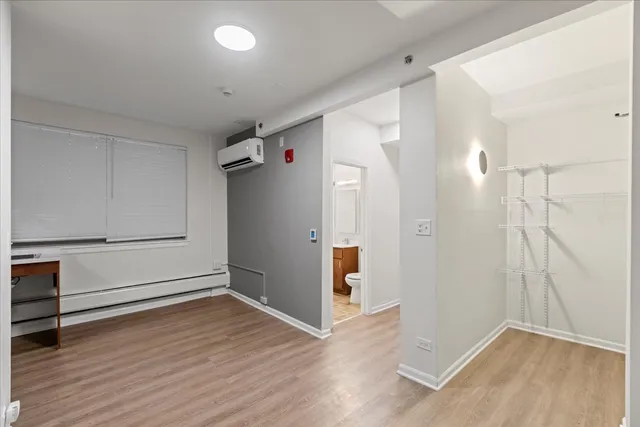 an empty room with wooden floor and cabinet