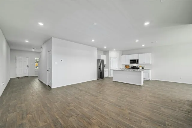 a view of kitchen with kitchen island and stainless steel appliances