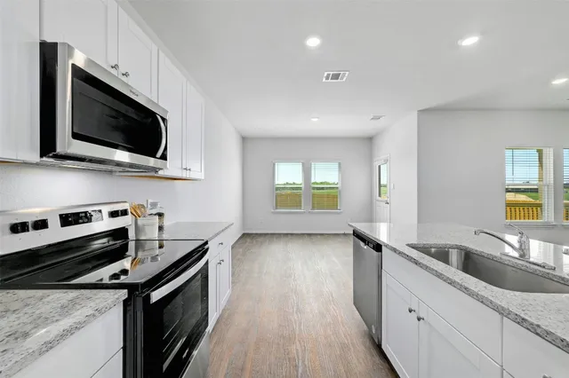 a kitchen with a sink stove and microwave