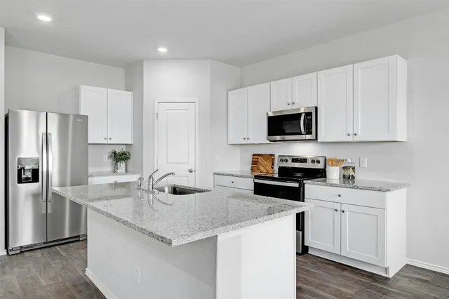 a kitchen with stainless steel appliances granite countertop a sink stove and refrigerator