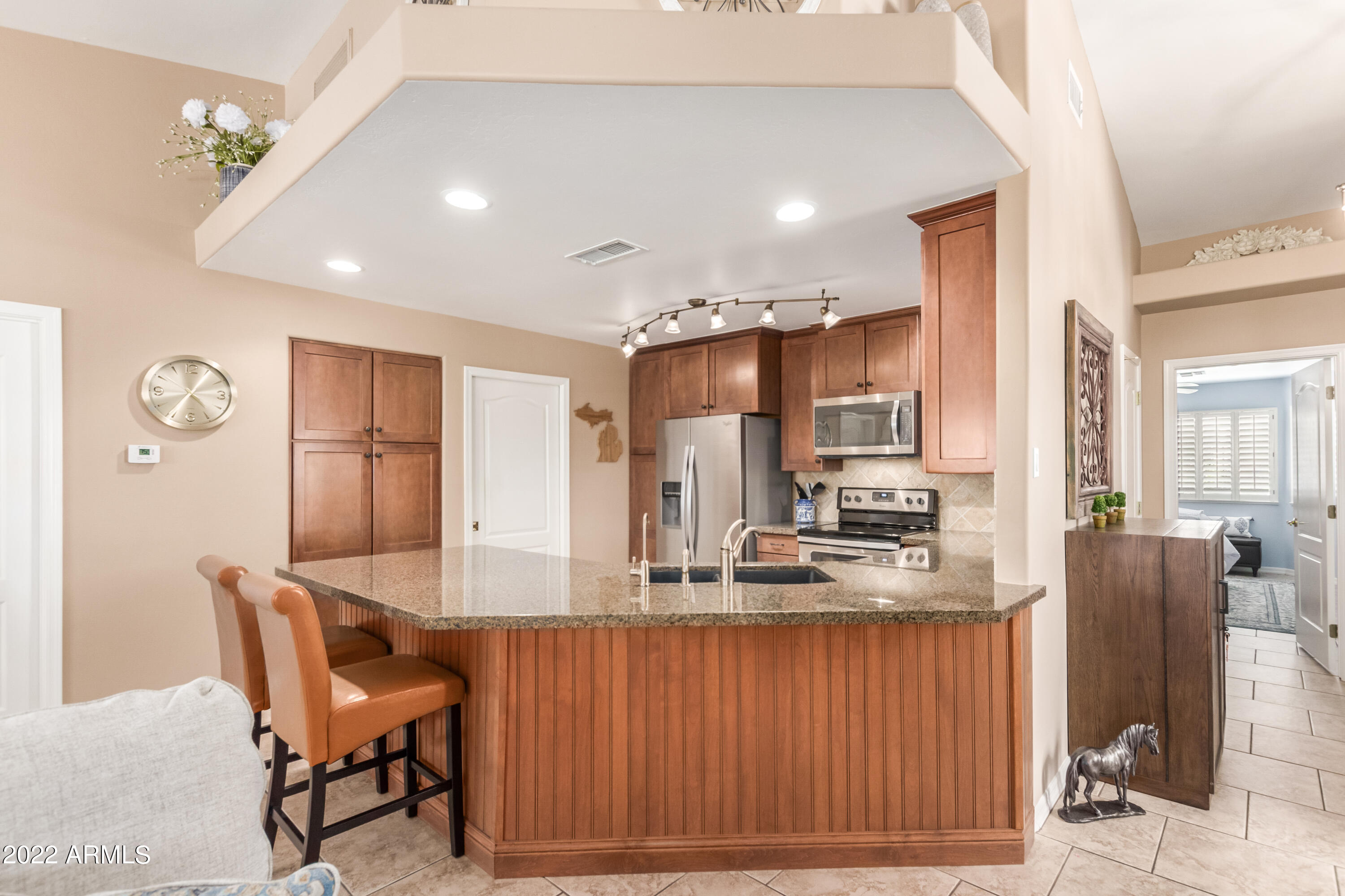 5830 East McKellips Road, Unit 76 Mesa, AZ 85215 - Photo 6 of 33 a kitchen with stainless steel appliances granite countertop a kitchen island a stove a sink a dining table and chairs