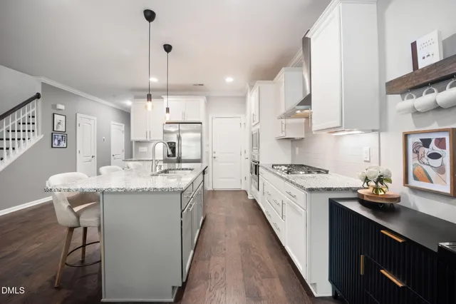 a kitchen with granite countertop a sink stove a dining table and chairs