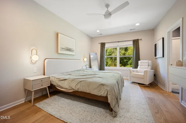 a bedroom with a bed wooden floor and window