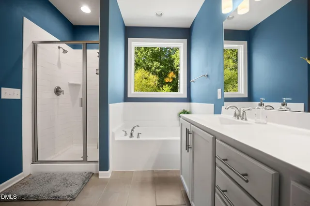 a bathroom with a tub a sink and window