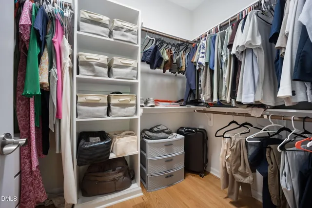 a view of walk in closet with clothes and shoes