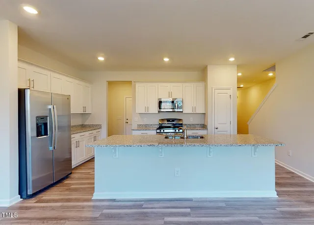 a kitchen with stainless steel appliances a refrigerator sink and stove