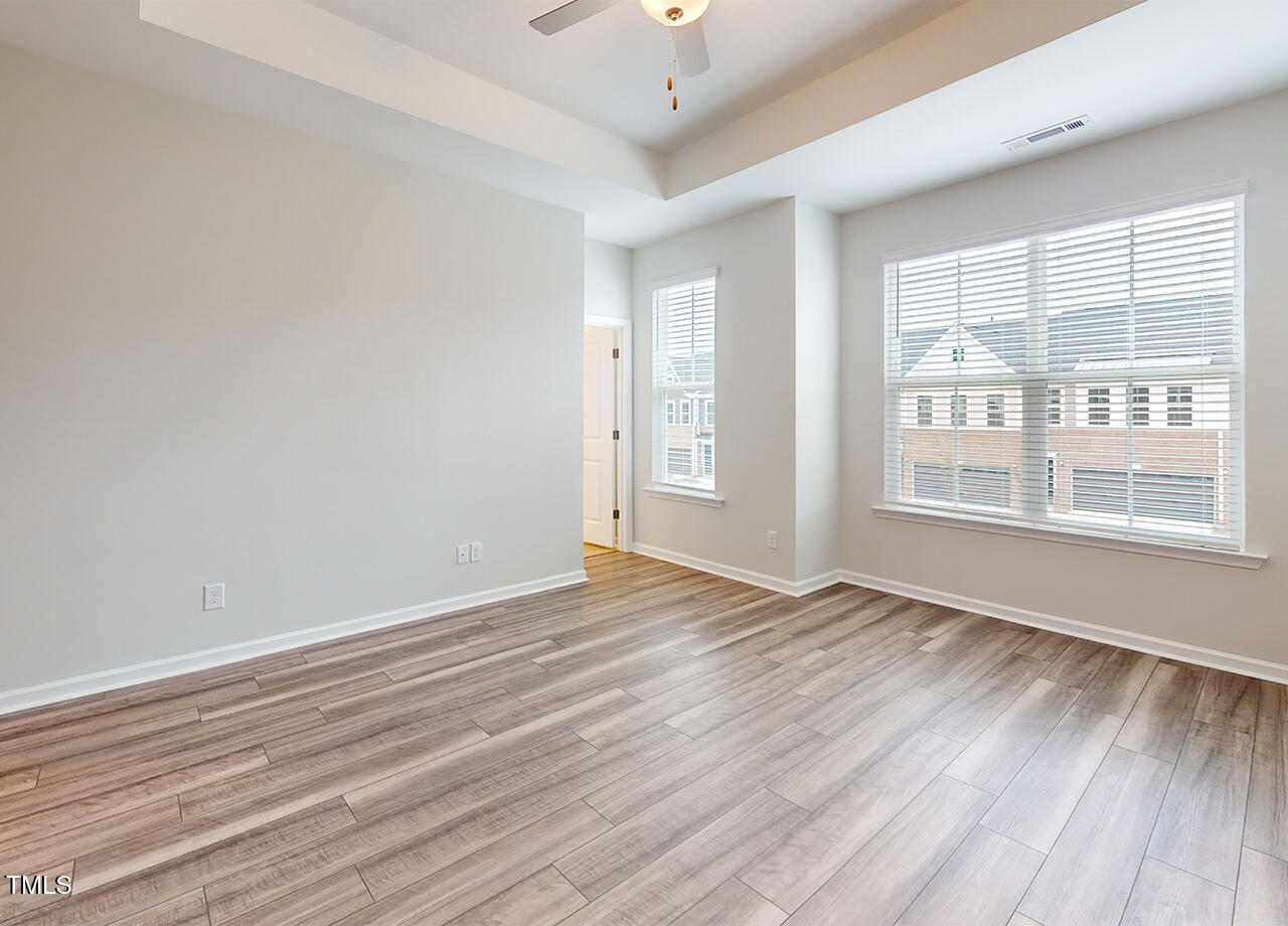314 Lemon Leaf Place, Unit MANDEVILLA Holly Springs, NC 27540 - Photo 3 of 23 a view of an empty room with wooden floor and a window
