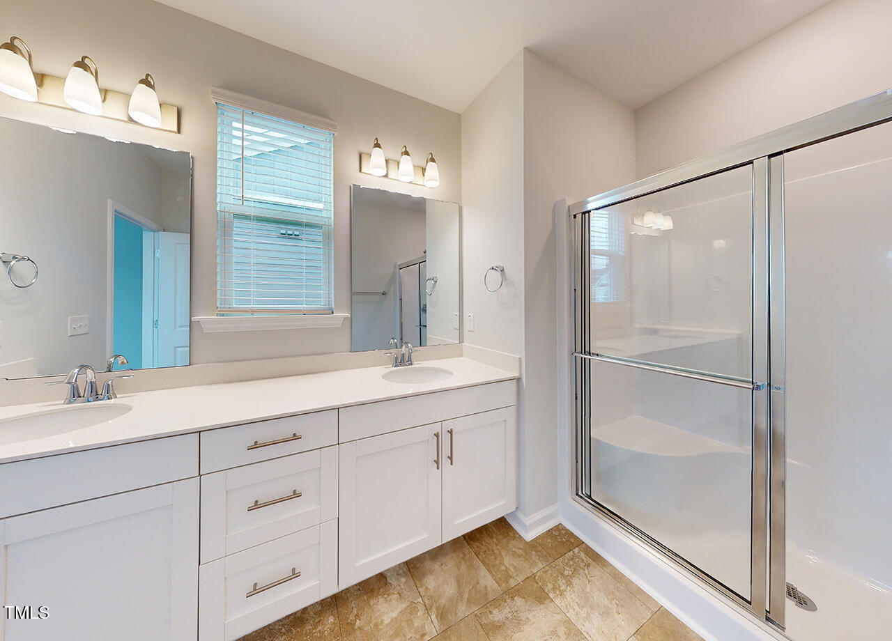 314 Lemon Leaf Place, Unit MANDEVILLA Holly Springs, NC 27540 - Photo 8 of 23 a spacious bathroom with a shower sink and mirror