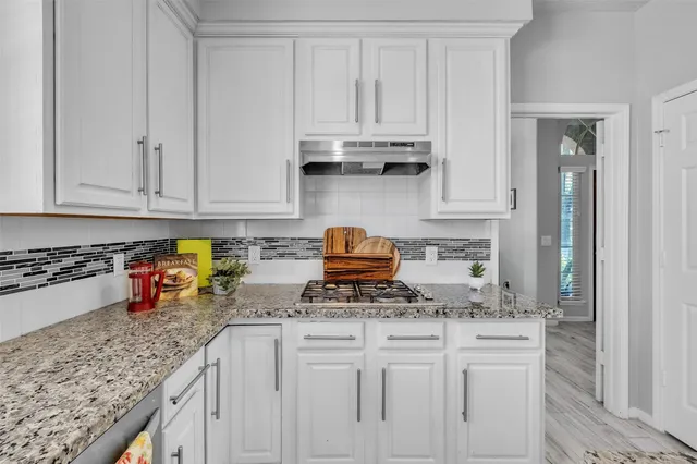 a kitchen with stainless steel appliances granite countertop a sink stove and cabinets