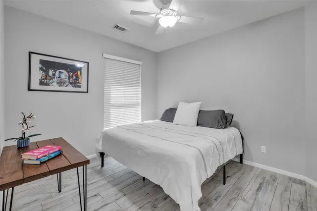 a bedroom with a bed and wooden floor