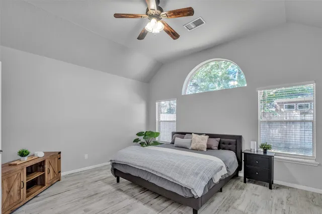 a spacious bedroom with a bed and a window