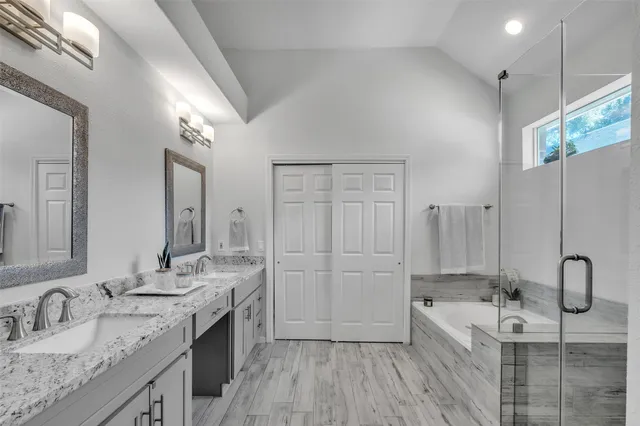 a spacious bathroom with a granite countertop sink a mirror and shower