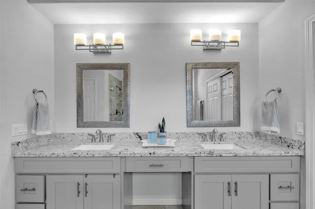 a bathroom with double vanity sinks and a mirror