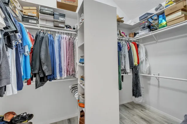 a view of walk in closet with clothes and shoes