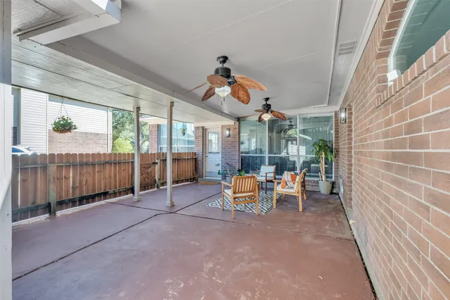 a view of a patio with a table and chairs and floor to ceiling window