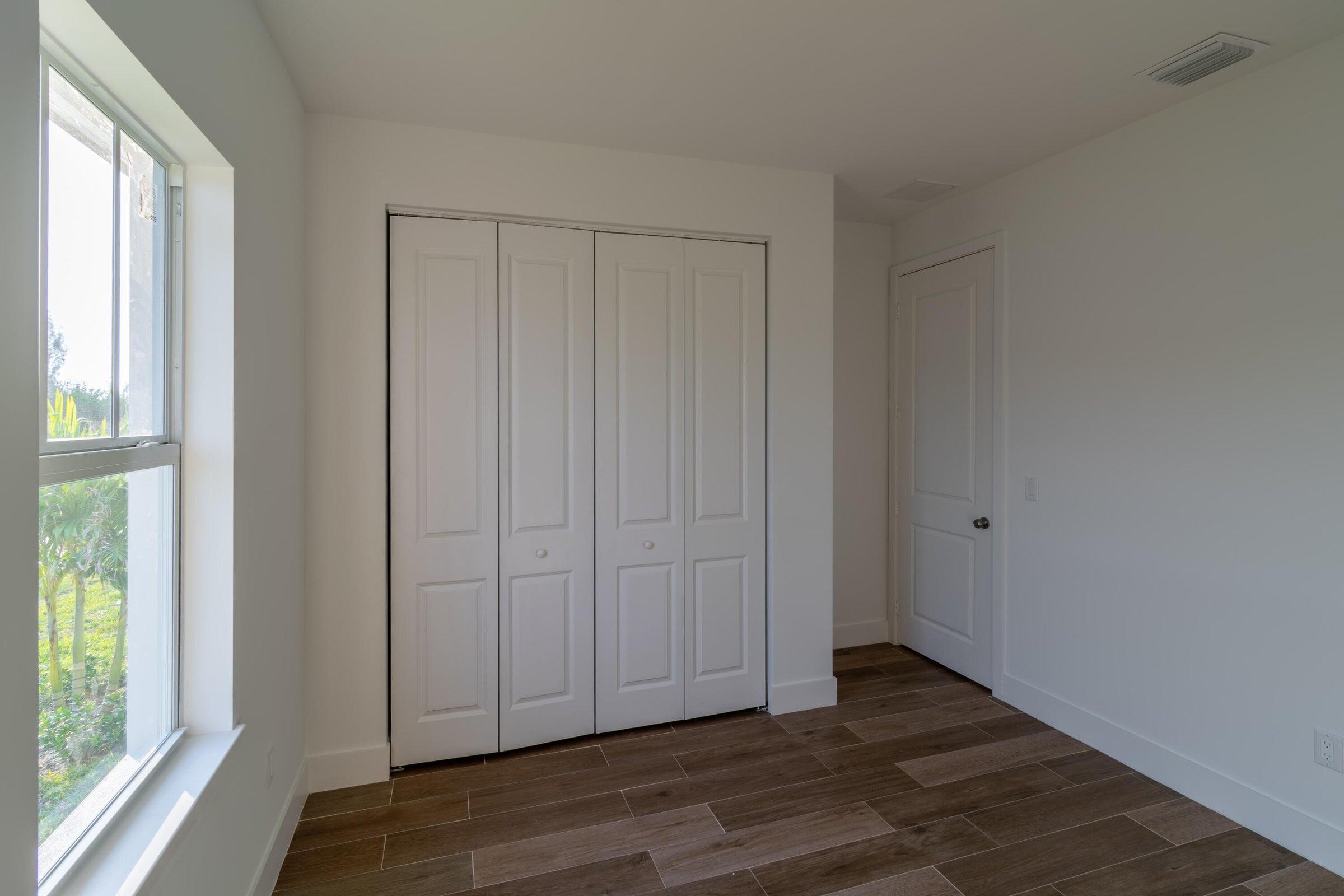 10625 Ayear Road Port Charlotte, FL 33981 - Photo 23 of 33 a view of empty room with wooden floor and fan